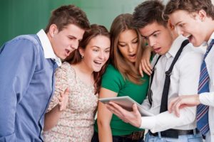 A group of five students looking at an awesome social media post