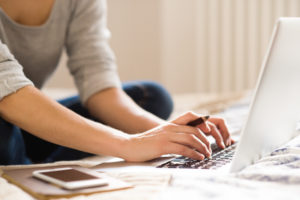 potential customer on bed with laptop searching for company website